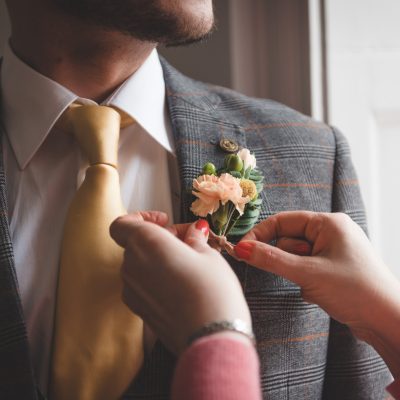The groom putting on his boutonniere